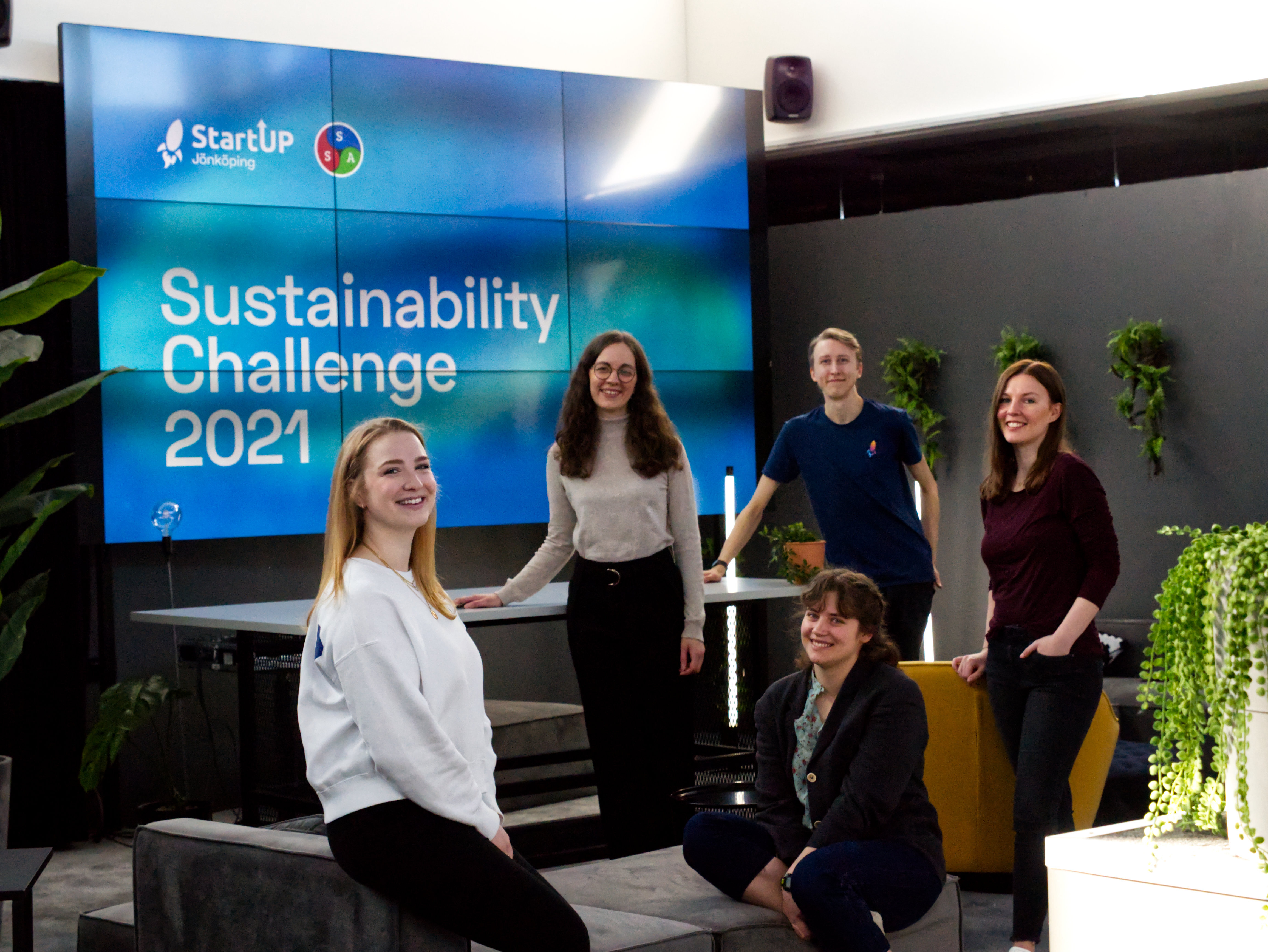 En grupp personer framför en stor tavla med texten Sustainability Challenge 20201