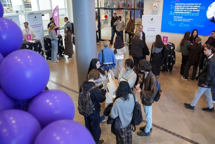 Lila ballonger och människor i ett rum