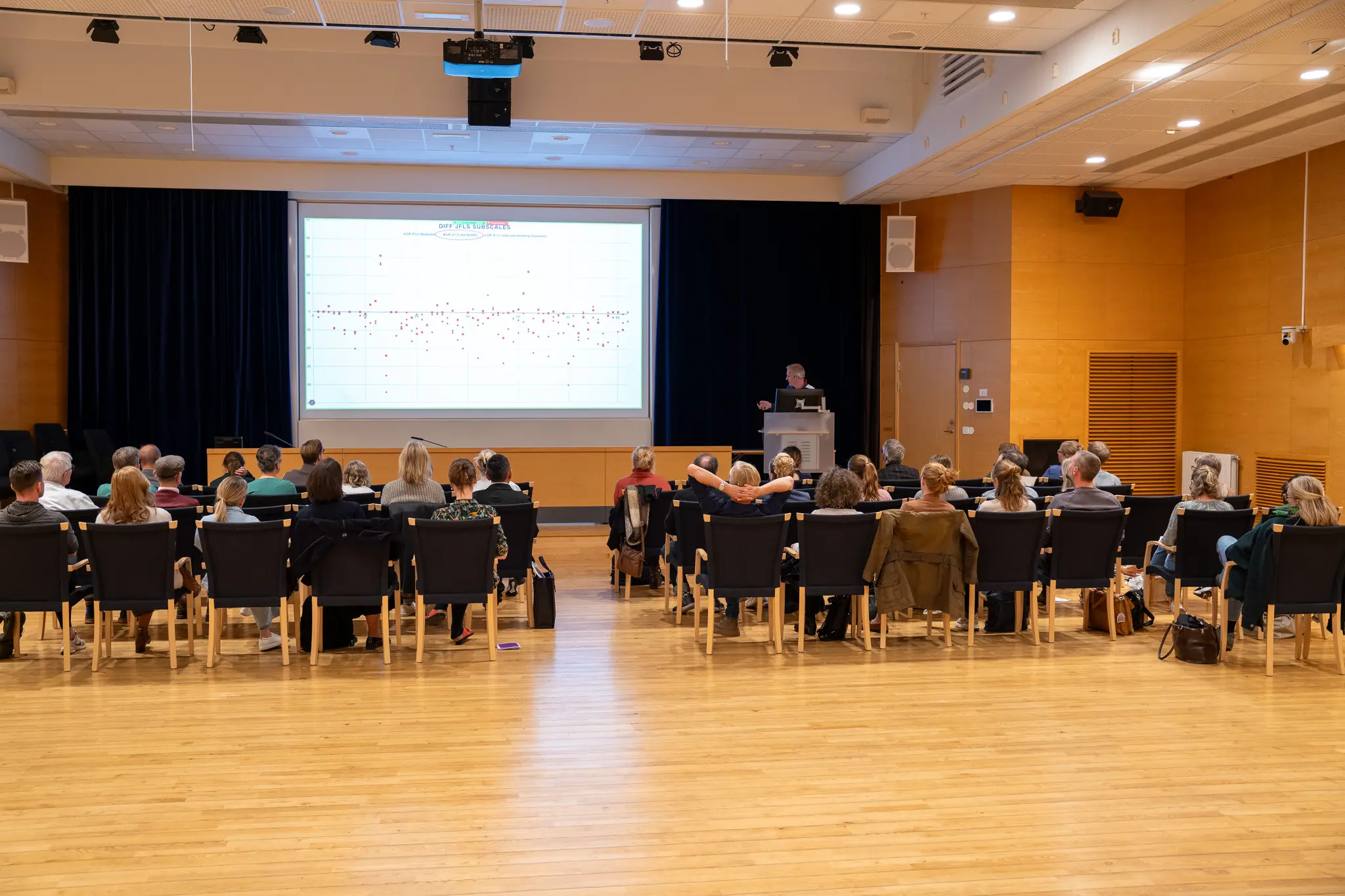 En grupp människor lyssnar på en presentation under en konferens.